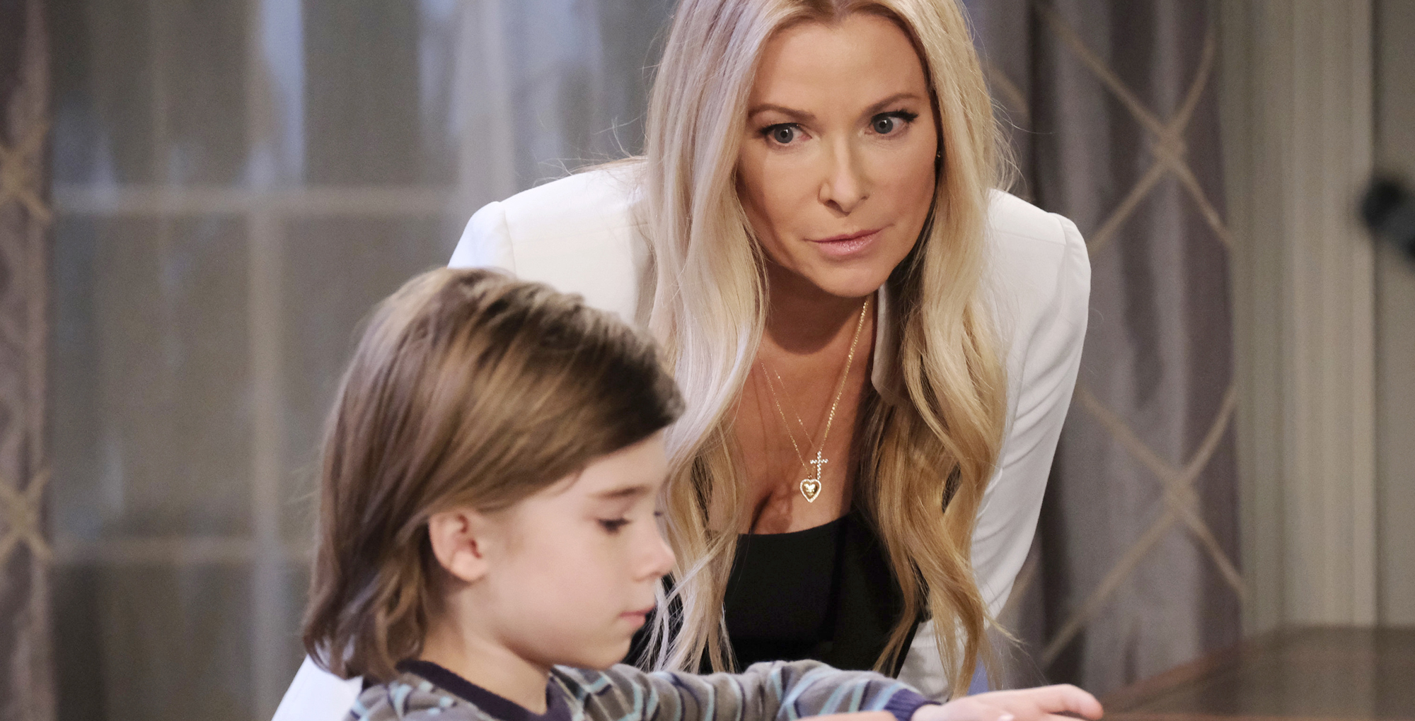 cady mcclain leaning over cary christopher in front of a window