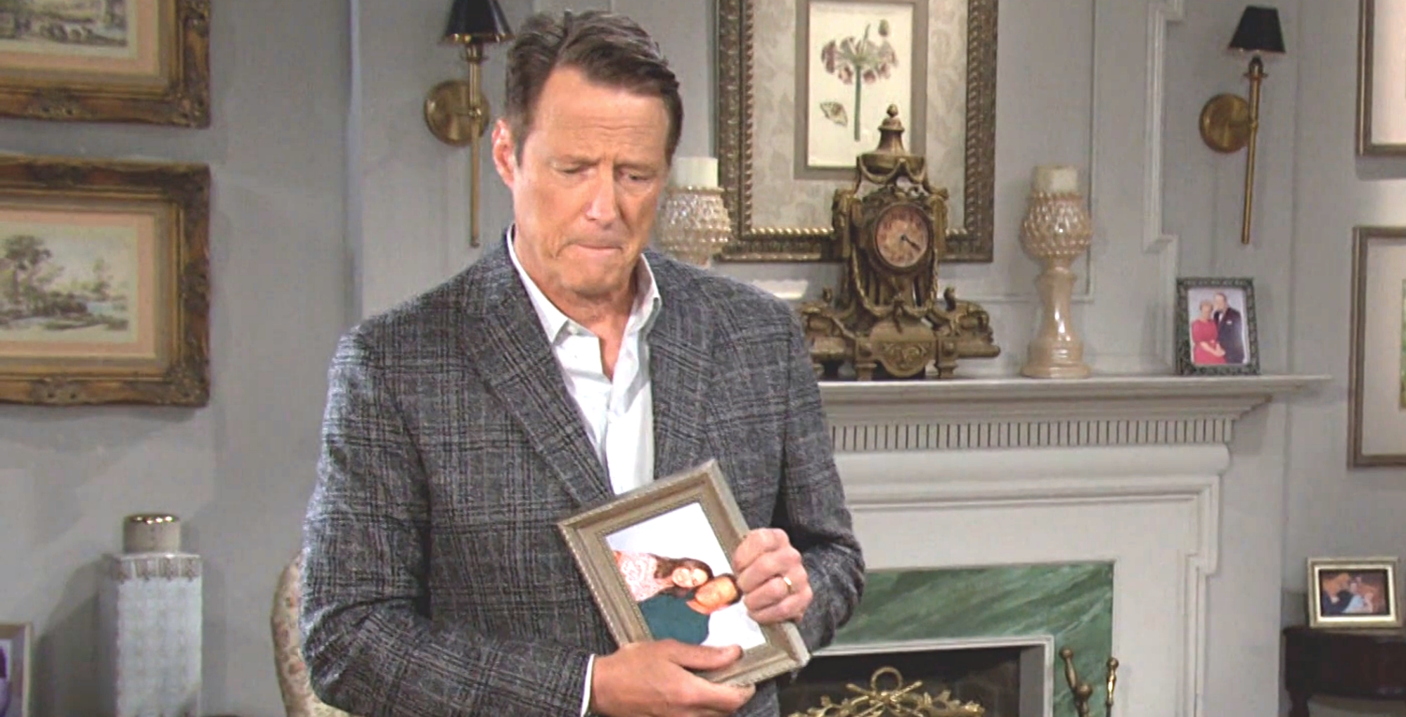 a suited jack deveraux clutches a framed photograph of him and gwen