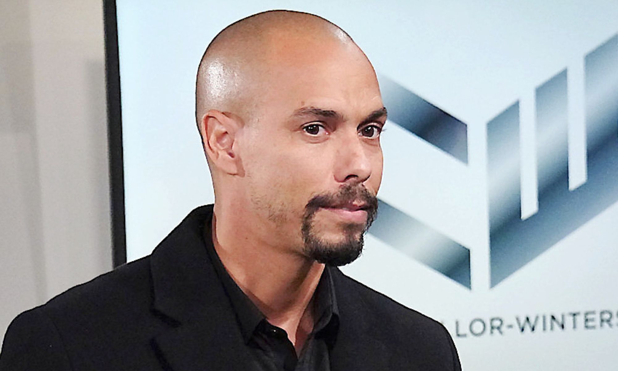 young and the restless spoilers devon wearing black in front of chancellor-winters logo