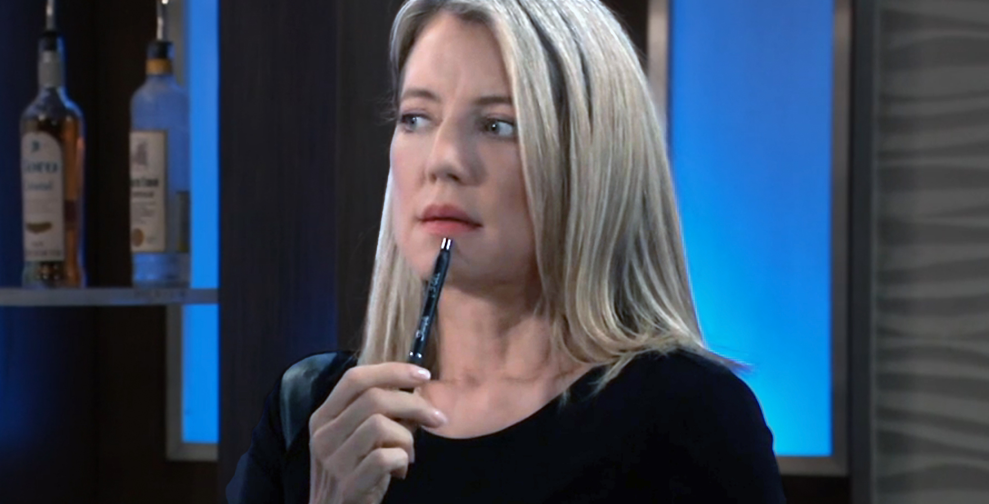 nina reeves at the metro court with a pen, thinking on general hospital.