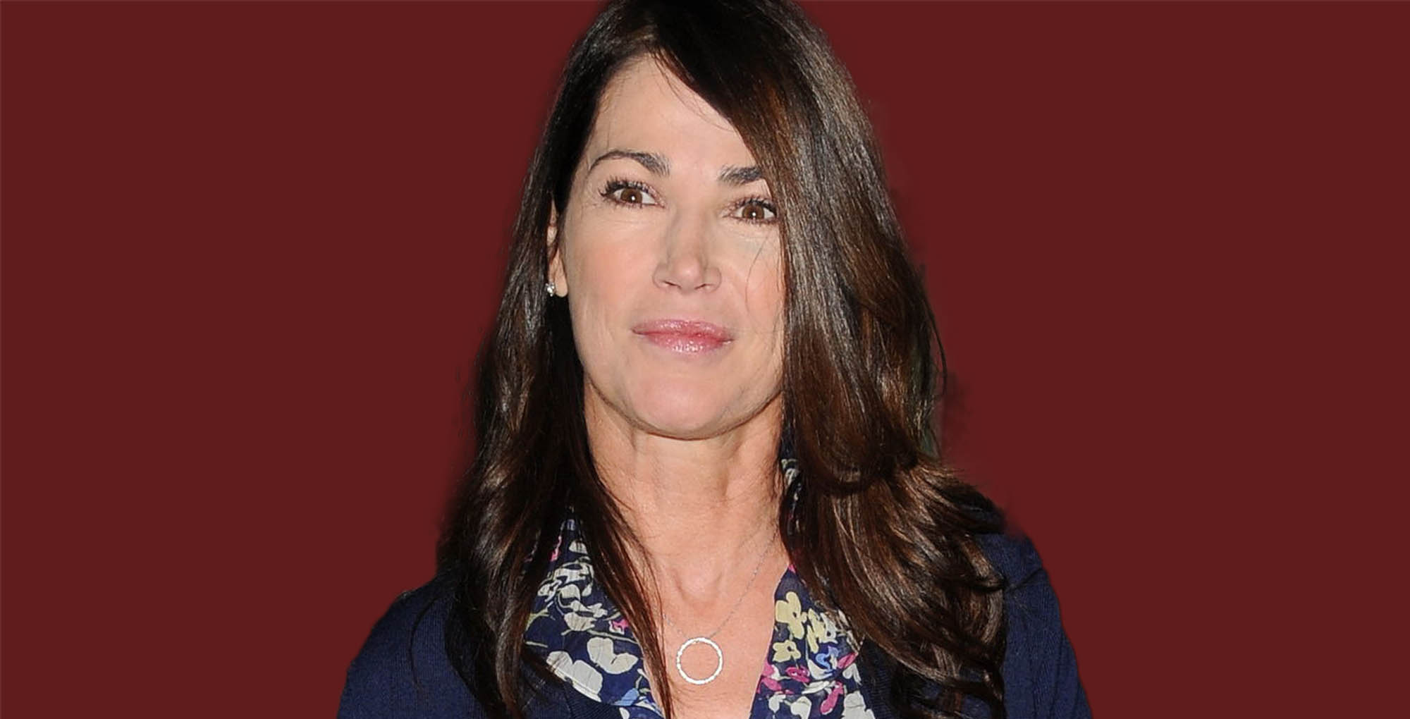 general hospital alum kim delaney against a dark red background.